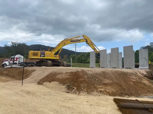 Excavator alongside precast culvert panels